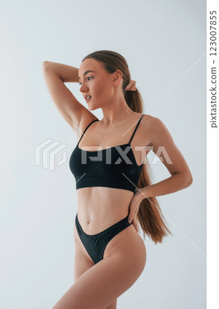 Beautiful female with brown hair. Woman in underwear with slim body type is posing in the studio 123007855