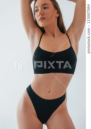 Fashion model. Woman in underwear with slim body type is posing in the studio 123007864