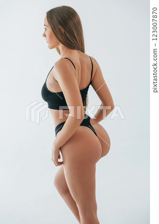 Showing new lingerie. Woman in underwear with slim body type is posing in the studio Showing new lingerie. Woman in underwear with slim body type is posing in the studio 123007870