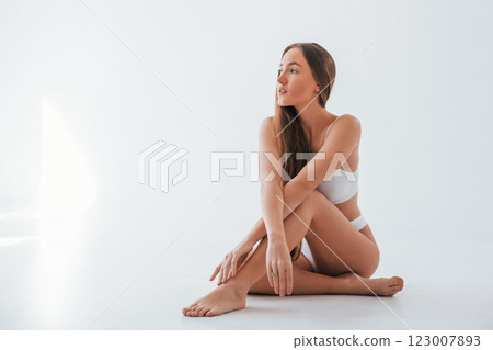Front view. Woman in underwear with slim body type is posing in the studio Front view. Woman in underwear with slim body type is posing in the studio 123007893