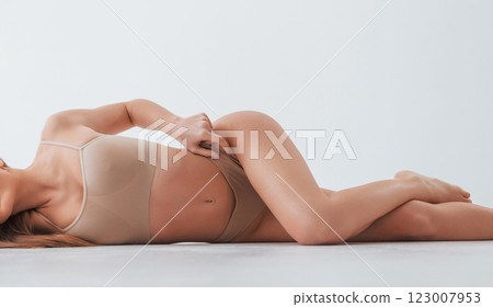 Close up side view. Woman in underwear with slim body type is posing in the studio Close up side view. Woman in underwear with slim body type is posing in the studio 123007953