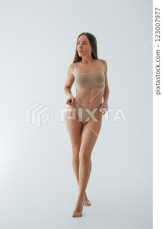 Full lenght view. Woman in underwear with slim body type is posing in the studio 123007977