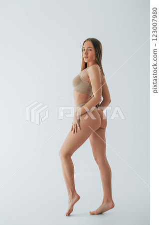 Full lenght view. Woman in underwear with slim body type is posing in the studio 123007980