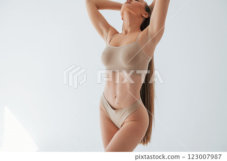 Full lenght view. Woman in underwear with slim body type is posing in the studio 123007987