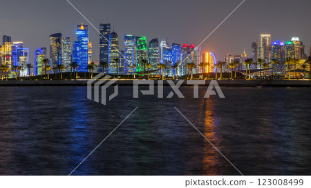 Doha city business downtown center panorama illuminated at night, with modern skyscrapers, promenade street with palms and sea in the foreground, Qatar Doha city business downtown center panorama illuminated at night, with modern skyscrapers, promenade street with palms and sea in the foreground, Qatar 123008499
