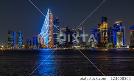 Doha city business downtown center panorama illuminated at night, with modern skyscrapers and sea in the foreground, Qatar 123008503