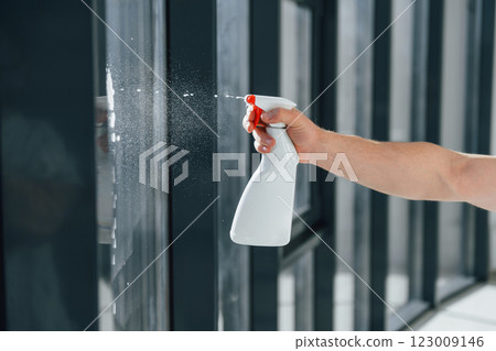 Close view of man's hand that holding bottle with washing liquid. Cleaning windows Close view of man's hand that holding bottle with washing liquid. Cleaning windows 123009146