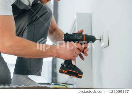 Close up view. Repairman is working indoors in the modern room Close up view. Repairman is working indoors in the modern room 123009177
