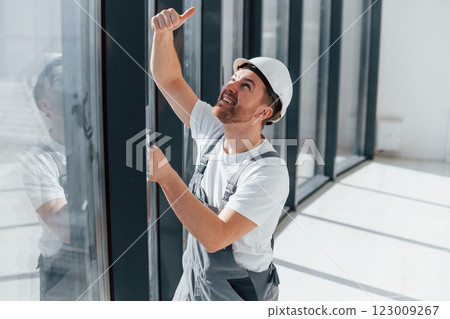 Repairman is working indoors in the modern room Repairman is working indoors in the modern room 123009267