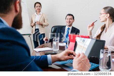 Business consultant listening to manager of corporation during meeting Business consultant listening to manager of corporation during meeting 123009534