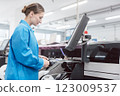 Worker confectioning electronic parts on assembly line 123009537