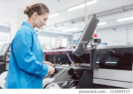 Worker confectioning electronic parts on assembly line Worker confectioning electronic parts on assembly line 123009537