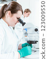 Female scientist using microscope in lab 123009550