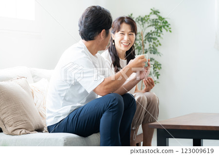 A couple in their 50s taking a coffee break in the living room 123009619
