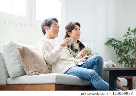 A couple in their 50s having tea time in the living room A couple in their 50s having tea time in the living room 123009957