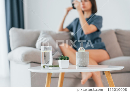 Doing make up. Close up view of table with glass of water. Young woman is at home. Conception of beauty 123010008