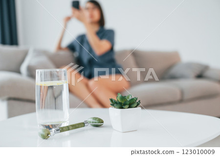 Doing make up. Close up view of table with glass of water. Young woman is at home. Conception of beauty Doing make up. Close up view of table with glass of water. Young woman is at home. Conception of beauty 123010009