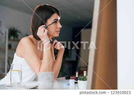 Doing eyelashes make up. Young woman is at home. Conception of beauty Doing eyelashes make up. Young woman is at home. Conception of beauty 123010023