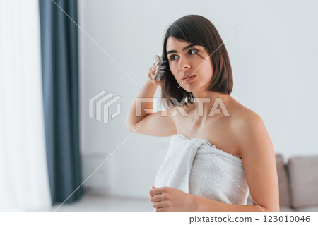 Combing hair. Young woman is at home. Conception of beauty 123010046