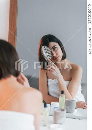Combing hair. Young woman is at home. Conception of beauty 123010049