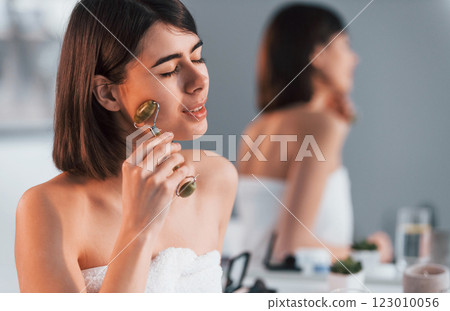 Close up view. Cleaning face skin by using special tool. Young woman is at home. Conception of beauty Close up view. Cleaning face skin by using special tool. Young woman is at home. Conception of beauty 123010056