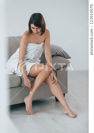 Shawing legs. Young woman is at home. Conception of beauty Shawing legs. Young woman is at home. Conception of beauty 123010079