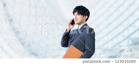 Smiling male businessman talking on a smartphone 123010260