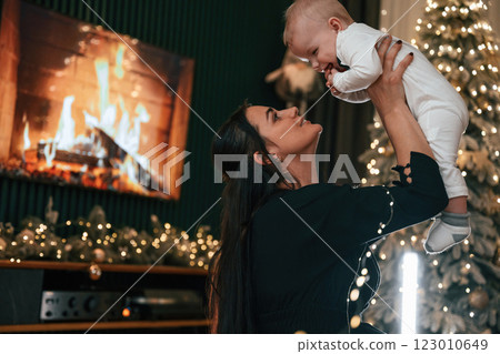 Mother with her little son is indoors, celebrating New Year Mother with her little son is indoors, celebrating New Year 123010649