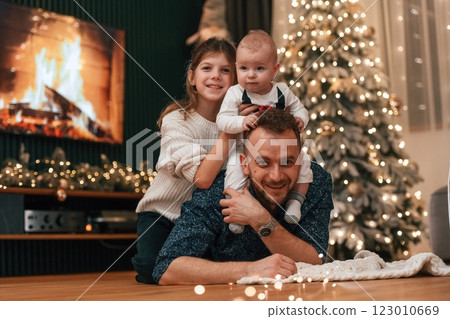 Father with his little son and daughter is lying down on the floor, celebrating new year 123010669