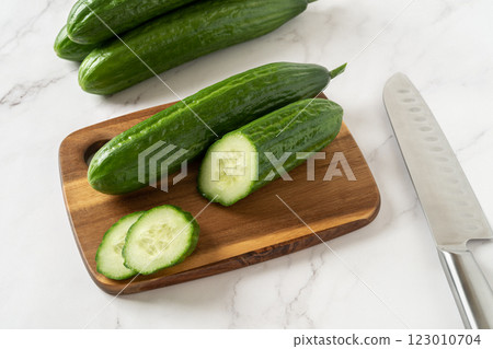 Cut in half cucumber on a wooden cutting board. Cut in half cucumber on a wooden cutting board. 123010704