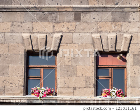 windows with flower pots on tuff facade of house 123011161