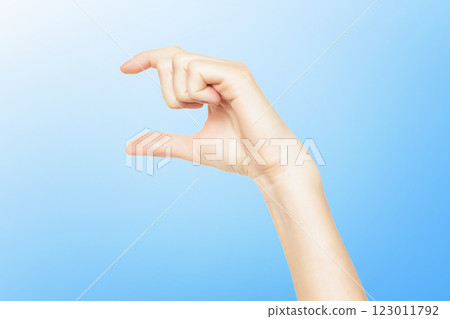 Female hand isolated at blue background making size measuring gesture. Female hand isolated at blue background making size measuring gesture. 123011792