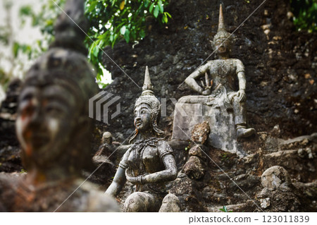 Row of old statues in secret buddhist garden. Concept of mysterious place for relaxation and meditation. 123011839