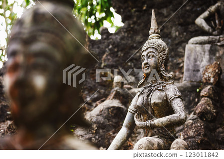 Row of old statues in secret buddhist garden. Concept of mysterious place for relaxation and meditation. Row of old statues in secret buddhist garden. Concept of mysterious place for relaxation and meditation. 123011842