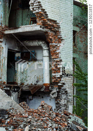 Image of a front of a ruined building with collapsed shelled brick walls anf floor and garbage around. Concept of natural disaster, war.ural disaster, war. 123011857