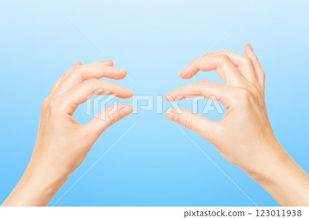 Female hands holding invisible object isolated at blue background. Female hands holding invisible object isolated at blue background. 123011938