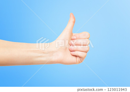 Female hand with thumb up gesturing success isolated at blue background. Female hand with thumb up gesturing success isolated at blue background. 123011943
