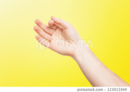 Closeup isolated male hand holding invisible object at yellow background. Closeup isolated male hand holding invisible object at yellow background. 123011949