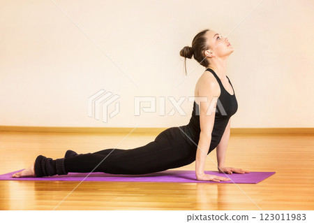 Young woman is training yoga in svanasana pose at gym. 123011983