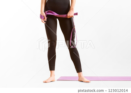 Slim athlete woman is holding trx straps for fitness training at isolated white background. 123012014