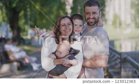 A joyful family relishing a beautiful sunny day by the sparkling water, capturing precious memories together A joyful family relishing a beautiful sunny day by the sparkling water, capturing precious memories together 123012363