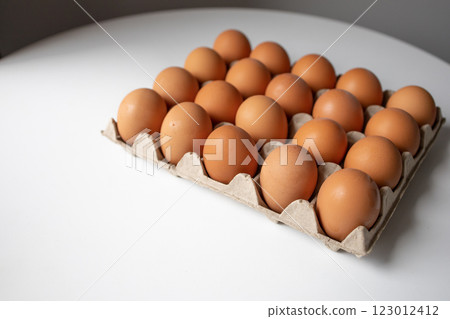 Chicken eggs in a paper tray lying on the table Chicken eggs in a paper tray lying on the table 123012412
