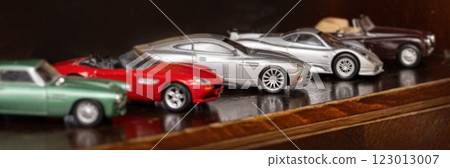 Collection of toy cars parked on wooden shelf Collection of toy cars parked on wooden shelf 123013007