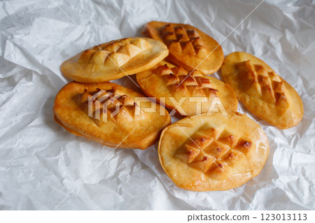 Polish traditional smoked cheese oscypek in white cooking paper Polish traditional smoked cheese oscypek in white cooking paper 123013113