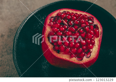 sliced fresh pomegranate, on a black plate, top view, rustic style, no people, sliced fresh pomegranate, on a black plate, top view, rustic style, no people, 123013229