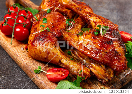 grilled fried chicken legs, served with fresh cherry tomatoes, and herbs, on a wooden chopping board, homemade, no people, 123013264