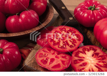 Freshly sliced, pink tomatoes, on a wooden chopping board, with a knife, rustic style, close-up, no people, Freshly sliced, pink tomatoes, on a wooden chopping board, with a knife, rustic style, close-up, no people, 123013268