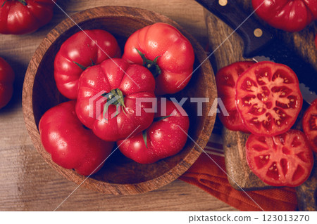 Freshly sliced, pink tomatoes, on a wooden chopping board, with a knife, rustic style, close-up, no people, 123013270