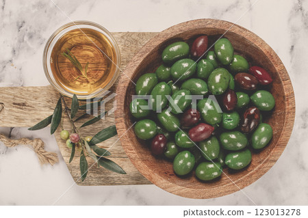 Chalkidiki olives, classic Greek green olives, in a bowl on a cutting board, top view, without people, 123013278