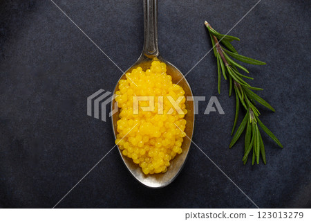 pearl yuzu, yuzu caviar - pearl, on a spoon, top view, on a dark gray plate, there are no people. 123013279